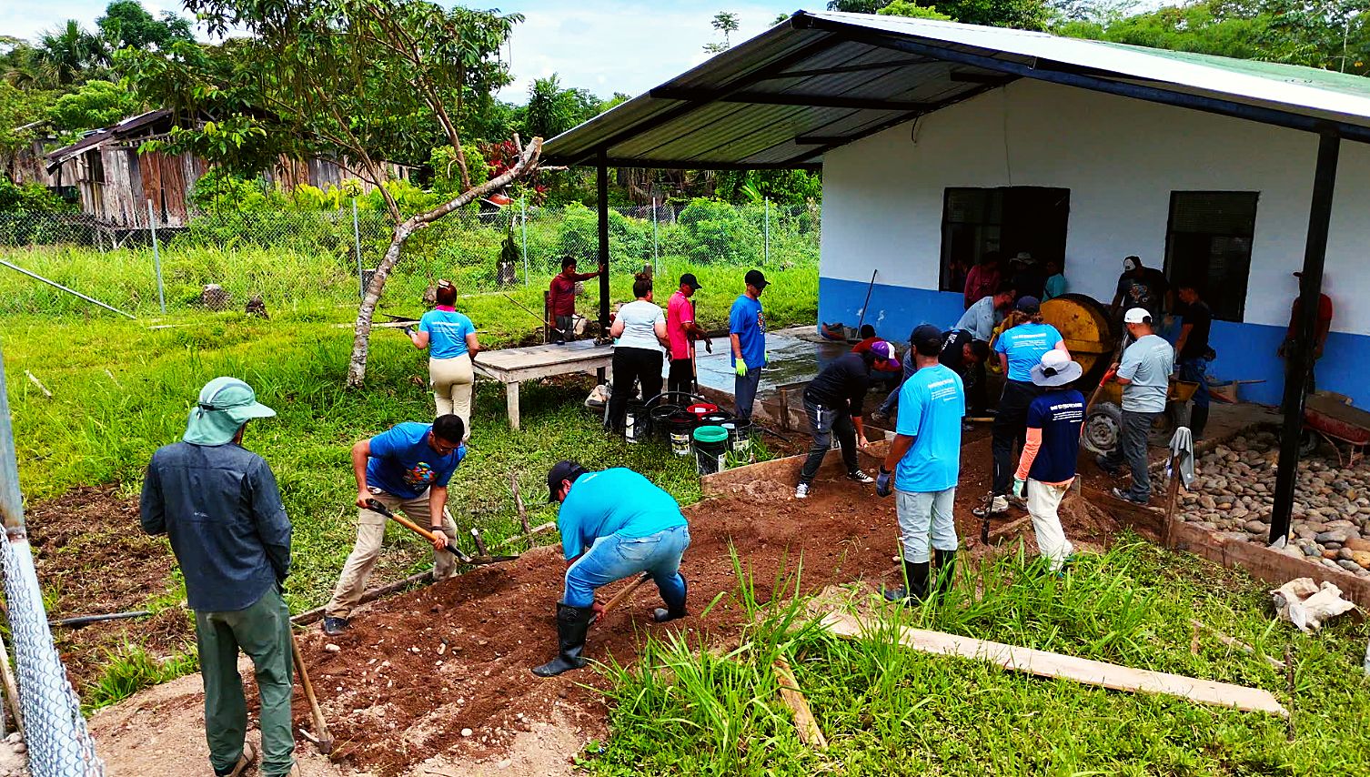 Volunteers and villagers digging and leveling beside the medical center