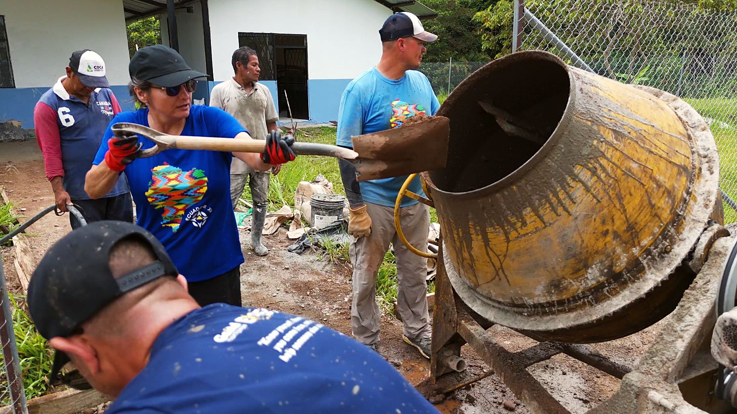Volunteers shoveling sand into the mixer